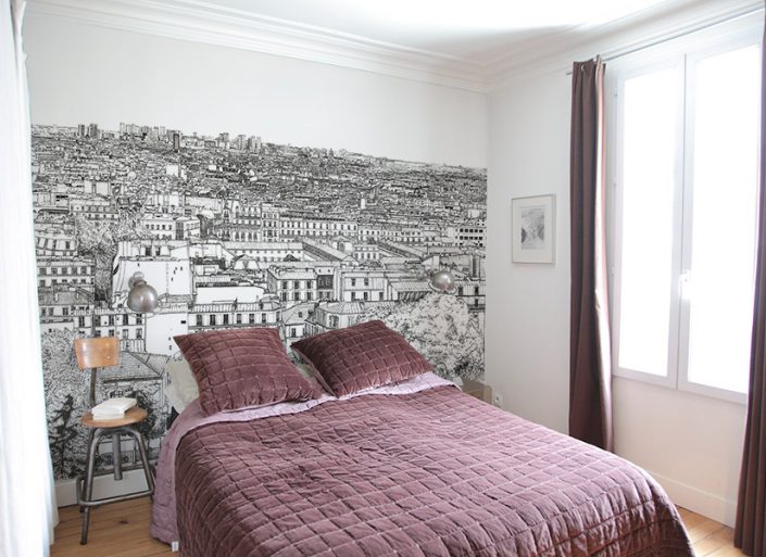 Une chambre avec un papier peint panoramique de Montmartre