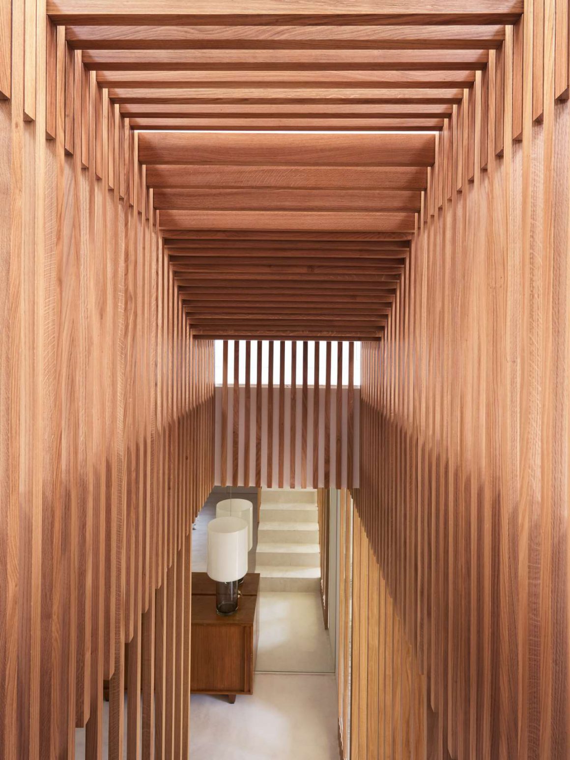 Couloir de l'escalier avec reflet des marches dans un miroir en face de lui qui ajoute de la profondeur. Un corps en bois pour un aspect design qui fait écho aux vieux appartements haussmanniens et aux escaliers de bateaux. 