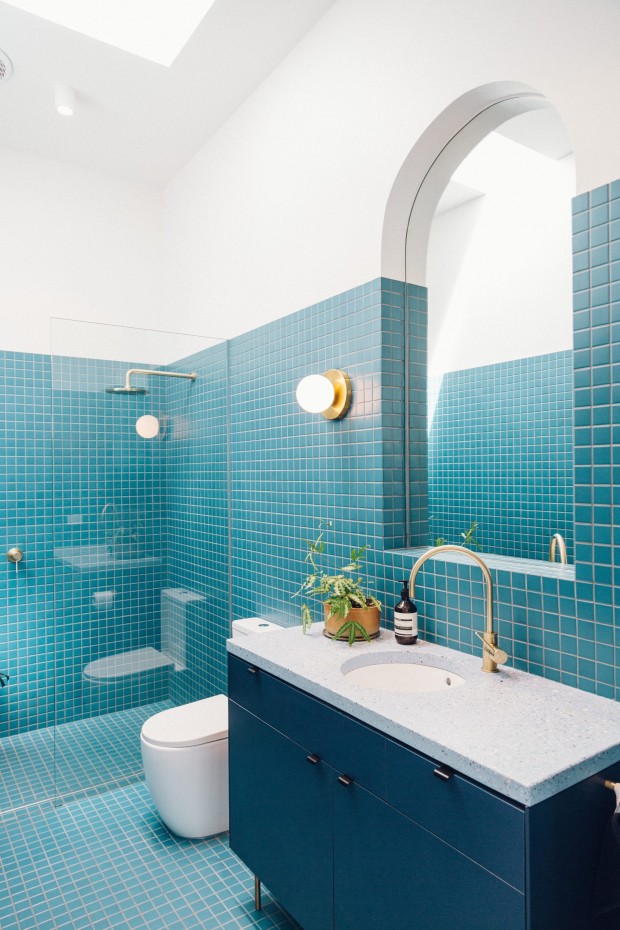 Salle de bain recouverte des carreaux bleus avec un miroir inspiré de l'architecture P&O. L'ambiance est inspirée des bateaux avec des tons bleu marine, turquoise et blanc. CP. Tash McCammon
