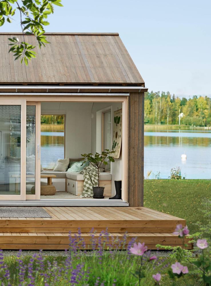 Une terrasse surélevée donne de la hauteur à la petite maison qui se fond dans le décor naturel grâce à sa structure en bois. 