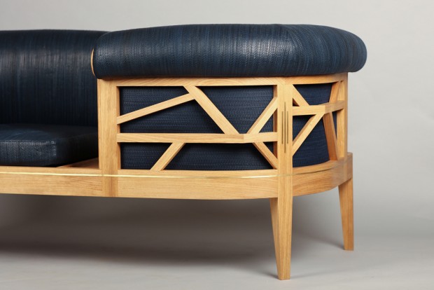 Une assise de Barley qui fait face à l'autre avec une structure en bois. Le dossier qui comprend les accoudoirs est avec des motifs géométriques et permet de faire ressortir et d'aérer le tissage en cuir bleu nuit. 