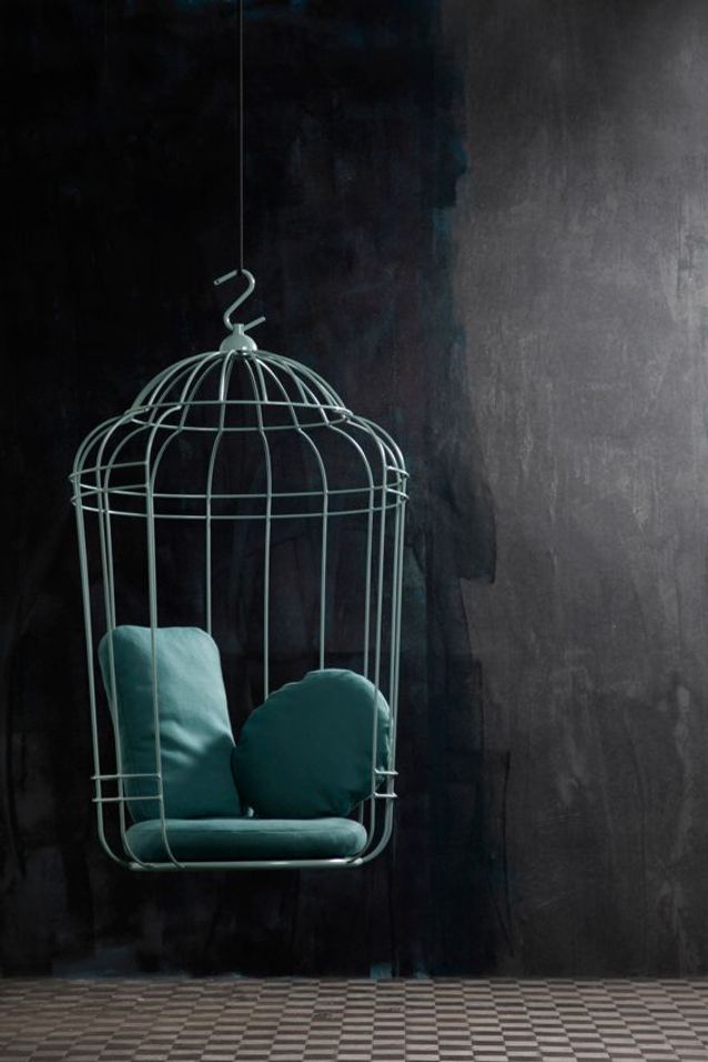 Fauteuil en forme de cage à perroquet en fer bleu avec des coussins du même ton pour plus de confort